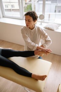 Fysiotherapeut voert beenbehandeling uit tijdens fysiotherapie sessie – belangrijk bij keuze voor fysiotherapie verzekering.”
